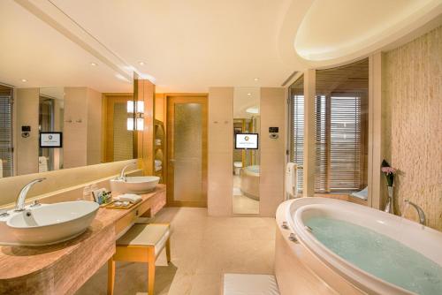 澳门澳门大仓酒店的浴室配有2个盥洗盆和1个浴缸。