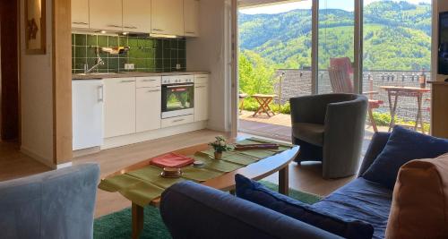 黑林山区舍瑙Ferienwohnung Traumblick的厨房以及带桌椅的起居室。