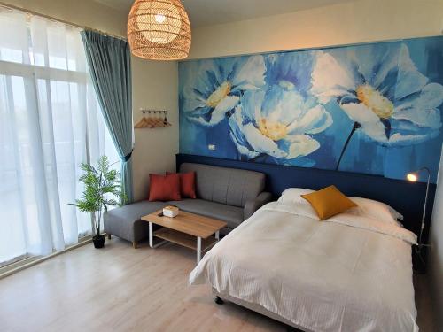 台东小斗宅生活民宿的一间卧室配有床、沙发和绘画