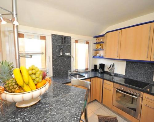 不莱梅Deluxe Apartments Bremen Typ D的厨房在柜台上放一碗水果
