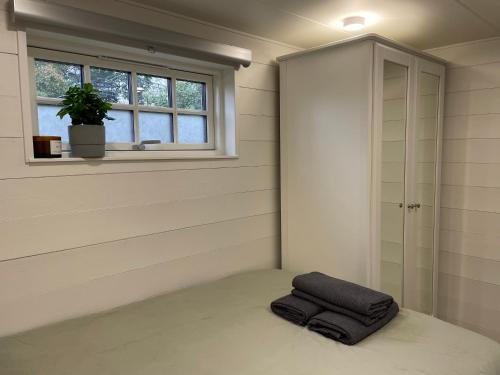 斯德哥尔摩Mini Villa Stockholm Älvsjö S61的窗户旁的地板上有一个枕头的房间