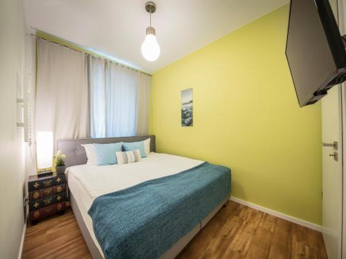 费曼城堡Strandburg Azurblau的一间卧室设有一张床和黄色的墙壁