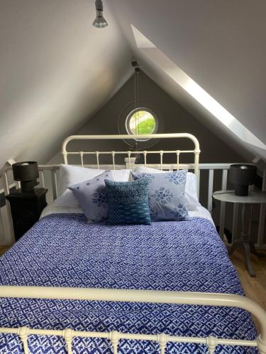 HinstockHolly Cottage The Studio的一间卧室配有一张带蓝色棉被的床