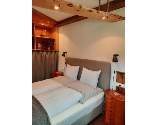 GrosspertholzLiving Legends - Tiny House auf den Wiesen der Edermühle的卧室内的一张带白色床单和枕头的床