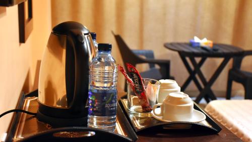 亚喀巴Al-Naher Al-Khaled Hotel的咖啡壶和桌子上的一瓶水
