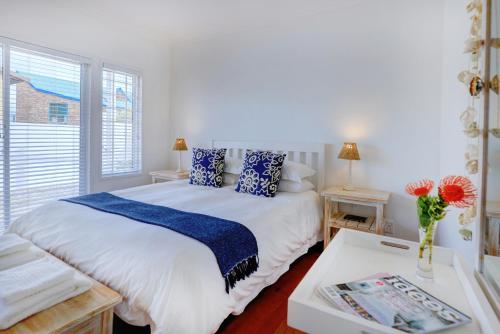 大布拉克勒菲Beach House 11B的一间卧室配有一张带蓝色枕头的床和一张桌子