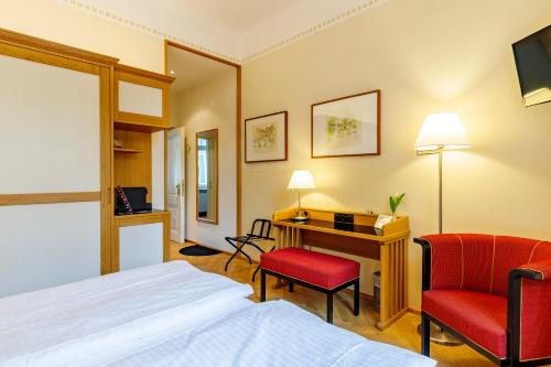 巴登赫泽格霍夫酒店的酒店客房配有一张床、一张桌子和一把椅子。