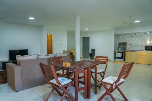 博瓦隆E&E自助旅馆的客厅配有木桌和椅子