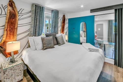 圣徒皮特海滩The Saint Hotel的卧室配有白色大床和蓝色的墙壁