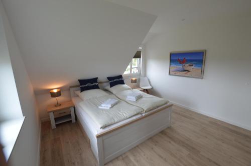 伯格奥夫费马恩Stadthaus 4, inkl 1 Parkplatz的小卧室配有带白色床单和蓝色枕头的床