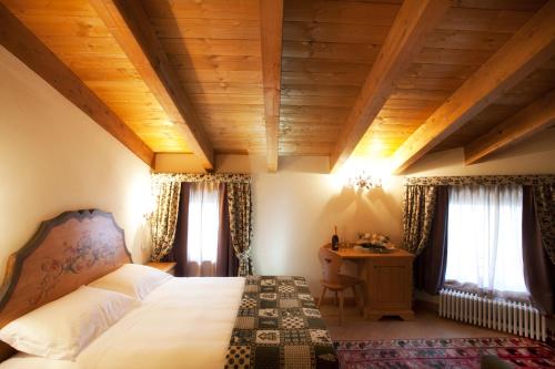 罗卡拉索Garnì Astoria Hotel & SPA的卧室配有床、桌子和窗户。