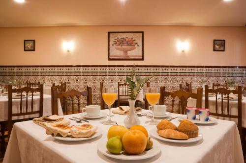 巴尼奥斯德蒙特迈奥尔Hotel Rural El Molino的一张桌子,上面放着食物和水果盘