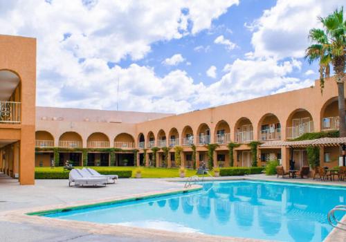 Camargo圣达菲酒店的一座大建筑,在庭院里设有一个游泳池