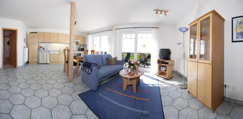 Meeschendorf"Ferienhof Sporleder" - Landhaus Nr1的客厅配有蓝色的沙发和桌子