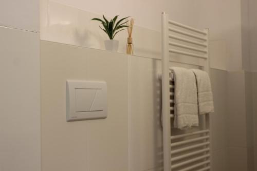 汉诺威HR RoomS的白色的浴室,配有毛巾架和植物