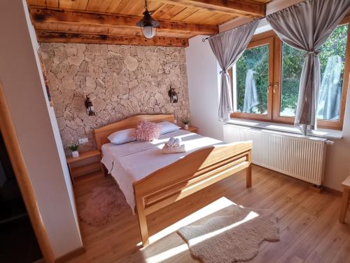 Gornji Babin PotokPlitvice Antico的一间卧室设有一张床和石墙