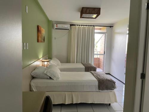 巴雷里尼亚斯Barreirinhas Lençois Flat的一间卧室设有两张床和窗户。
