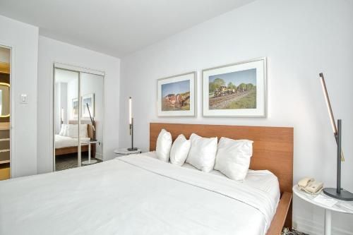 多伦多Town Inn Suites Hotel的白色卧室配有一张带白色枕头的大床