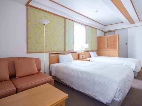 长崎古欧莱酒店长崎站前的酒店客房,设有两张床和一张沙发