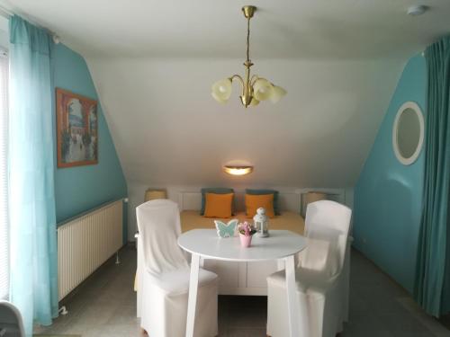 格罗森布罗德Ferienwohnung Schmetterling II的一间设有白色桌子和白色椅子的用餐室