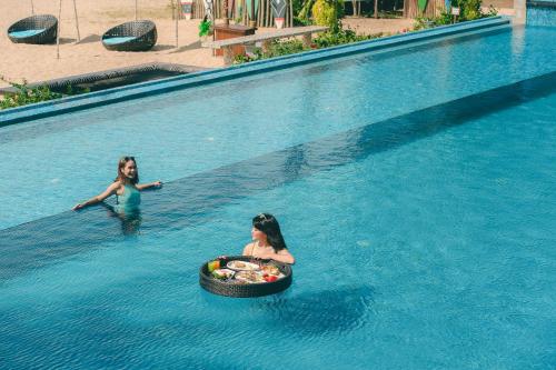 奎武里奎布里德凡达拉海滩别墅酒店的两个女孩在游泳池里,在水里打球