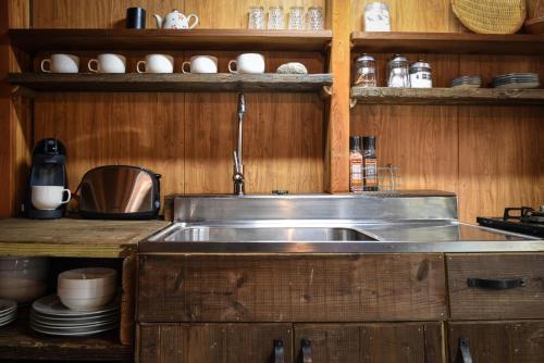 白马村小屋度假屋的厨房配有不锈钢盥洗盆和木柜