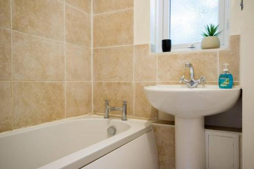 纽伯里Central quiet self check in 1 bedroom apartment up to 4的浴室配有盥洗盆、浴缸和盥洗盆