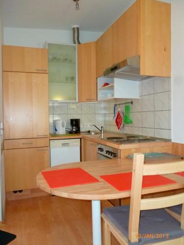 伦茨堡Ferienwohnung Tietgen的厨房配有木制橱柜和木桌。