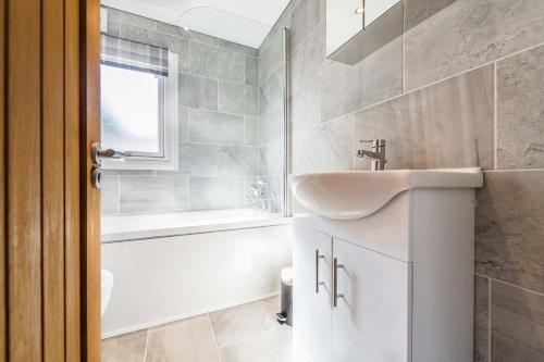 林肯Hideaway by Liv Retreats的浴室配有盥洗盆和浴缸。