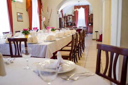 阿尔巴诺拉齐亚莱阿尔缇耶利别墅酒店的长餐厅设有桌椅和玻璃杯
