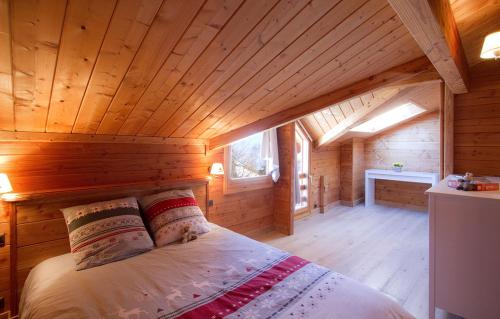 莱德萨阿尔卑斯Odalys Chalet Le Panorama的小木屋内一间卧室,配有一张床