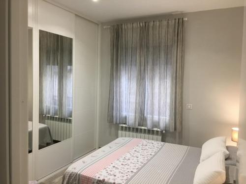 马德里Apartamento estilo nórdico en Malasaña (Madrid Centro)的一间卧室配有一张床和镜子