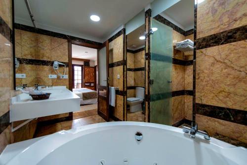 洛斯克里斯蒂亚诺斯天堂公园趣味时尚酒店的带浴缸和盥洗盆的大浴室