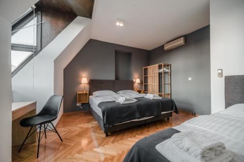 萨格勒布Lux Apartments的一间卧室配有两张床和椅子