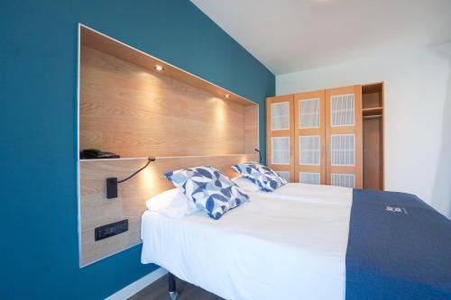 普雷塔斯Playitas Hotel - Sports Resort的卧室配有白色大床和蓝色的墙壁