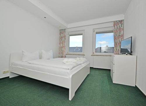 岑平Ferienanlage Zempin Haus Achterwasser的白色的卧室设有白色的床和窗户。