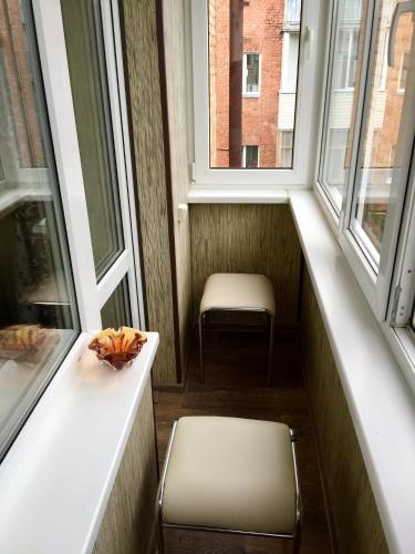 切尔尼戈夫Апартаменти的一个带椅子的小阳台和两个窗户