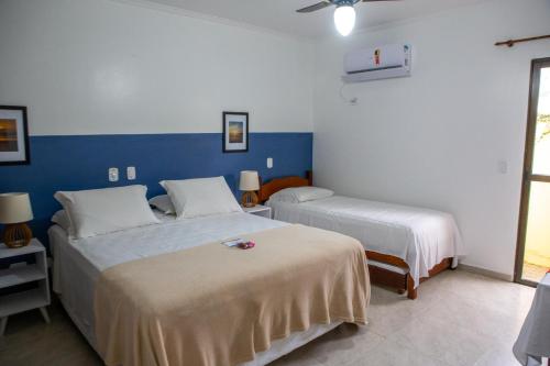 巴雷克萨巴Pris Hotel的配有2张床的蓝色和白色墙壁客房