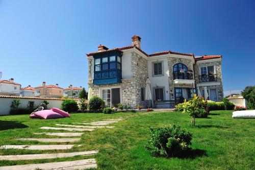 阿拉恰特Alaçatı Sultan Konak Butik Otel ℳℛ Luxury Concept的大房子,有一个大院子,有草地