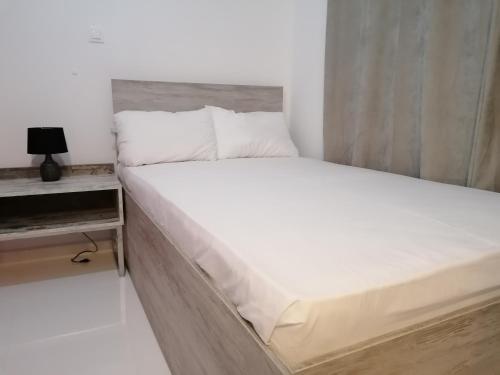 罗德镇Jz Plus Classio的卧室配有白色大床和床头柜。