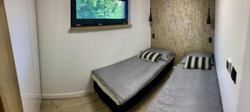 卡鲁扎Chata Thermal House的客房设有两张床和一台墙上的电视
