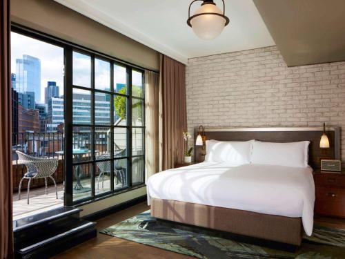 伦敦Mondrian London Shoreditch的一间卧室设有一张大床和一个大窗户