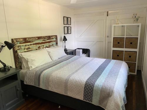 萨维特尔Boatsheds的一间卧室配有带条纹被子的床