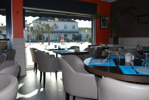 莱萨布勒-多洛讷Cit'Hotel Le Chêne Vert的街景餐厅,配有桌椅