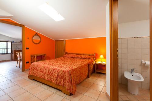 阿西西全景农家乐的一间卧室设有橙色的墙壁、一张床和一个水槽