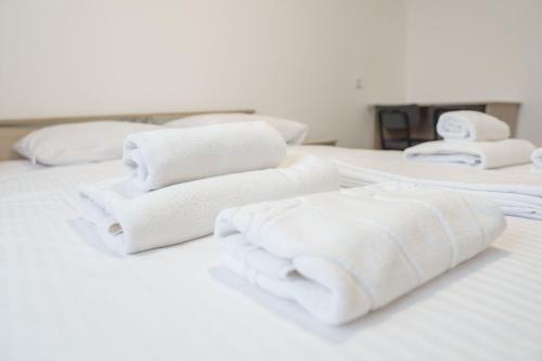 科克舍套Гостиница Kokshe Inn的一组白色毛巾,坐在床上