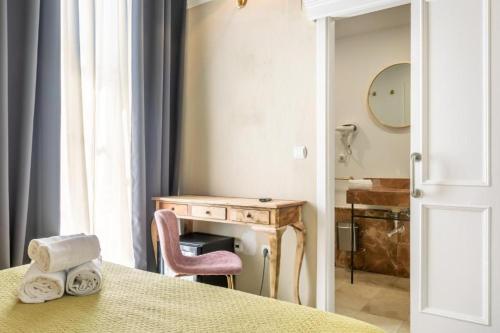 赫雷斯-德拉弗龙特拉Catedral Suites Jerez的客房设有桌子、书桌和椅子