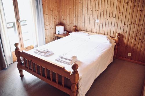 莫尔金斯Chalet Le Jeuna的一间卧室配有一张带白色床单的床和一扇窗户。