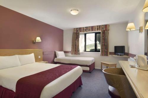 兰伯恩戴斯梅姆伯雷酒店的酒店客房配有一张床、一张沙发和一张书桌。