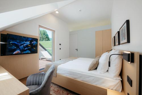 多布尔纳Spa Suite Dobrna - Terme Dobrna的一间卧室配有一张床、一张书桌和一个窗户。